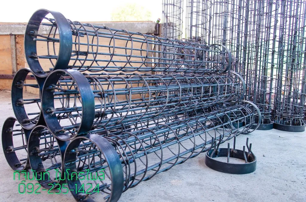 โครงเหล็กทรงกระบอกหลายชุดวางซ้อนกัน เห็น Dowel, Spiral และวง Flat Bar ที่ปลายโครง