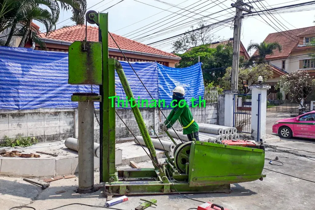 เครื่องตอกไมโครไพล์และท่อนเสาเข็มบริเวณทางเข้าบ้าน