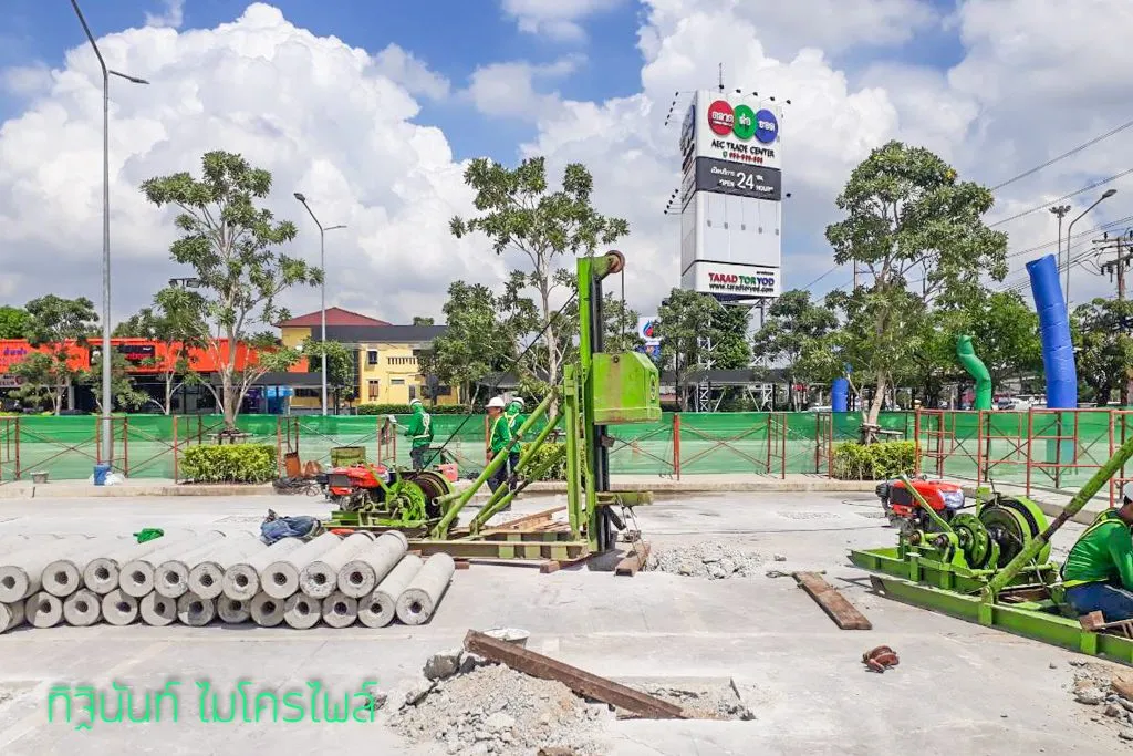 ปั้นจั่นไมโครไพล์สองชุดและกองท่อนเสาเข็มหน้าป้าย AEC Trade Center
